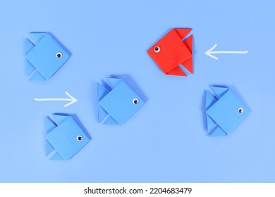 Red Paper Fish Swimming Swimming Against The Current In Opposite Direction Of Blue Fish