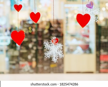 Red Paper Hearts And Snowflakes Hanging On Threads On Blurred Background