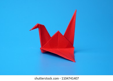 Red Paper Origami Crane On Blue Background