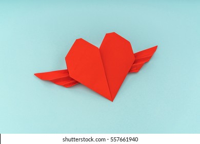 Red Paper Origami Heart With Wings On Blue Background