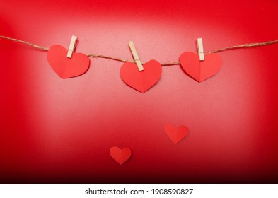 Red Paper Origami Hearts On Craft Rope Isolated On Red Background. Small Hearts Go Down. Valentine's Day, 8 March, Birthday, Wedding Concept. Love, Charity. Top View.