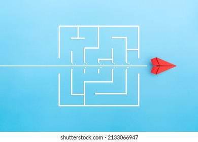 Red paper plane breaking through maze on blue background, Concept of overcoming barriers, goal, target