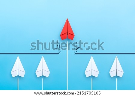 Red paper plane breaking through obstacle on blue background, Concept of overcoming barriers, goal, target