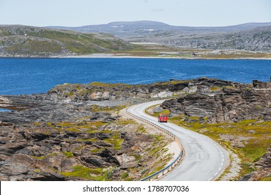 A Red Parcel Delivery Van On Curvy Road In Northern Norway In Summer