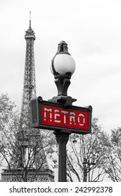 Red Paris metro subway entry sign with Eiffel tower in the background, Paris, France 