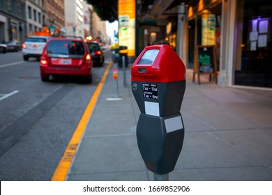 Red Parking Meter or Parking machine with electronic payment in the city streets and a row of cars