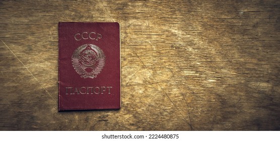 The red passport of the Soviet Union on an old wooden table. A civil passport of the USSR.