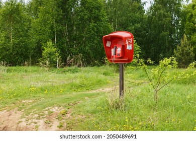 red payphone. Payphone standing in the field. Village telephone. Russia