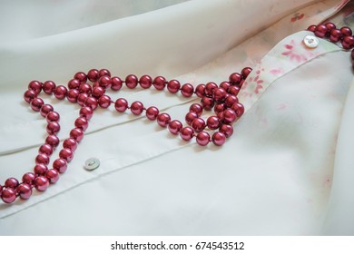Red Pearl Necklace On Silk Shirt