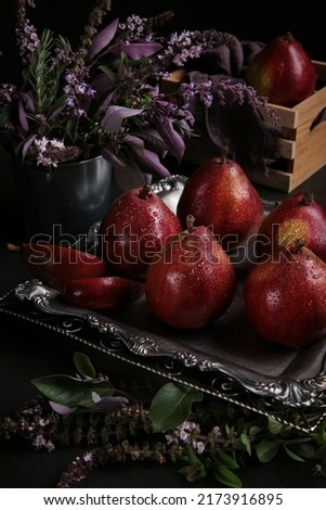 Red pears Red Bartlett sort in a low key on the black background. Dark photo with the pears.