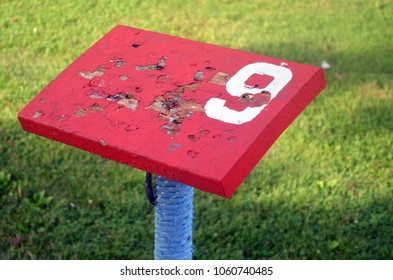 Red Peeling Wooden Score Card Table At Mini Golf Course