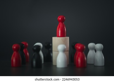 A red peg doll on top of wood block surrounded by many peg dolls. Human resource management concept, one leader standing in front of them, leadership concept, recruiting workers - Shutterstock ID 2246943053
