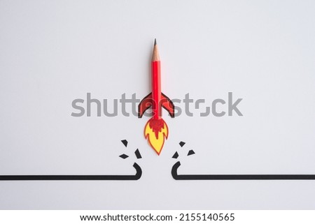 Red pencil rocket breaking through black wall obstacle on white background minimal style. Concept of breakthrough for new idea, innovative and successful goal in business financial.