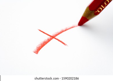 Red pencil writing an X