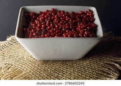 RED PEPPER CORNS IN A WHITE RECTANGULAR CERAMIC DISH
