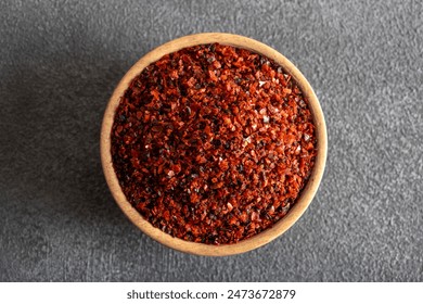 Red pepper flakes.Red chili peppers in wooden bowl on black background