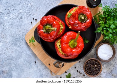 Red pepper stuffed with meat, bulgur and vegetables in a cast-iron pan. Baked stuffed peppers.