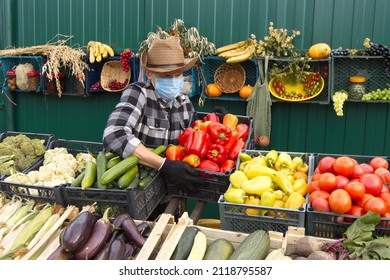 Red Peppers At The Farmers' Market. A Male Salesperson Puts A Box Of Red Pepper On The Counter.
The Seller In A Protective Medical Mask.