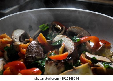 Red peppers, mushrooms, onions and parsley are fried in a pan. - Powered by Shutterstock