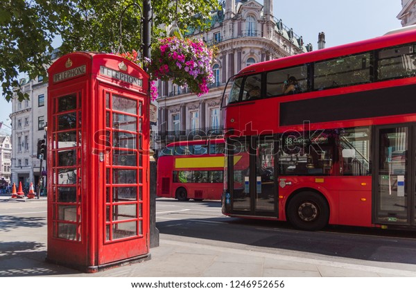 red phone booth with colored flowers and
red bus, england, great britain,
london