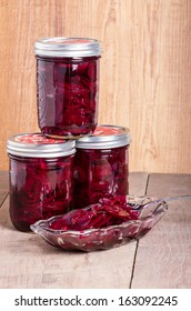 Red pickled beets in mason jars being served in a bowl