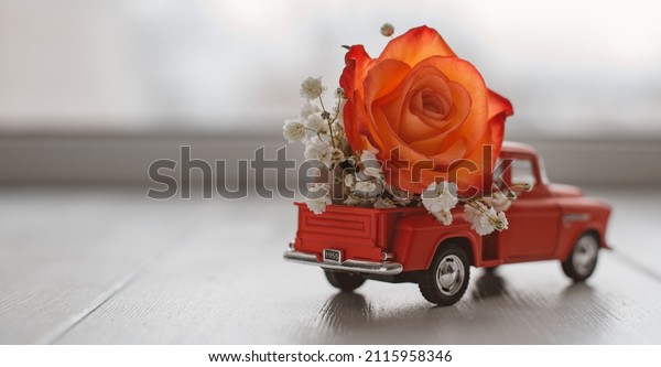 red pickup retro toy car delivering\
bouquet of flowers. February 14 card, Valentine\'s day. Flower\
delivery. 8 March, International Happy Women\'s\
Day.
