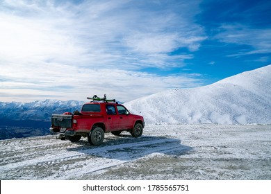 Red Pickup Truck On Road, Beautiful Winter Road Under Snow Mountains New Zealand.