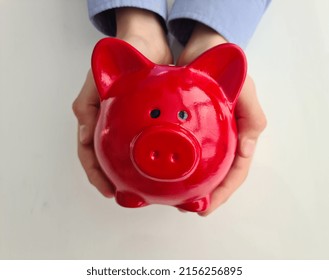 Red piggy bank in children hands and children allowances. Baby savings and pocket money concept - Powered by Shutterstock