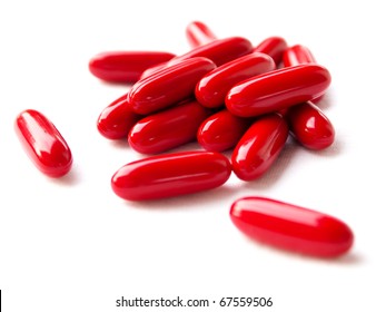 Red pills spilled on white background
