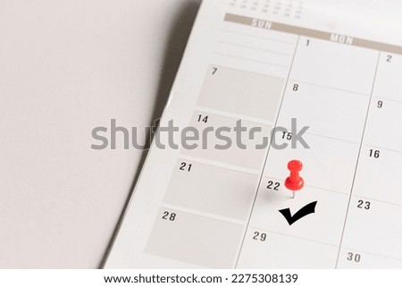 Red pin and arrow symbol on calendar. Confirmation of appointment or meeting concept.