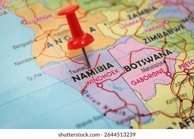 A red pin marks Namibia on a political map, highlighting its desert terrain and wildlife conservation areas. Excellent for ecotourism and land use studies.