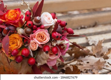 Red Pink Orange Autumn Bouquet By Florist With Rose Flowers, Fall Leaves, Rosehip Berries And Acorn Close Up, Floral Background