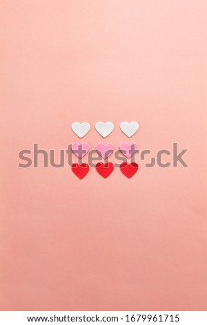 Red, pink and white hearts arranged on pink background with white frame