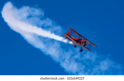 Red plane performing acrobat maneuvers