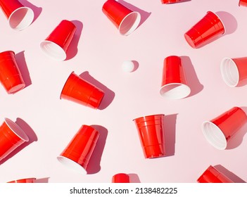 Red plastic beer pong cups on pink background. Flat lay.