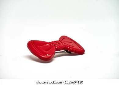 Red plastic bow on white background