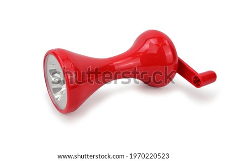 Red plastic flashlight with a dynamo typewriter. Flashlight without batteries. Isolated on white background.