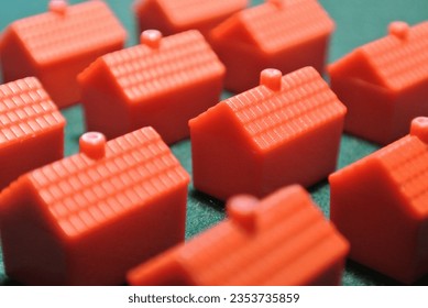 Red plastic monopoly houses hotels on green background