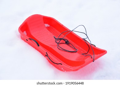 Red Plastic Sled On Snow In A City Park