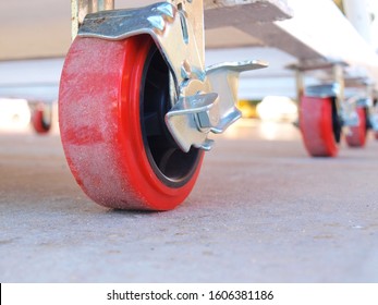 Red plastic trolley wheels On a cement floor background. selective focus