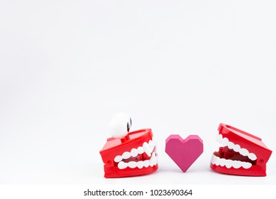 Red Plastic Wind Up Chattering Teeth biting paper box red heart shape at Valentine's Day.Concept Valentine's Day, Day of love