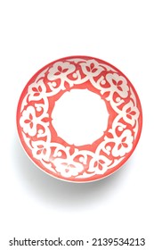 A red plate for food decorated with white national ornaments on a white background - Shutterstock ID 2139534213