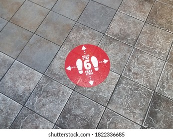 Red Please Stay Six Feet Apart Sign On Grey Tiles