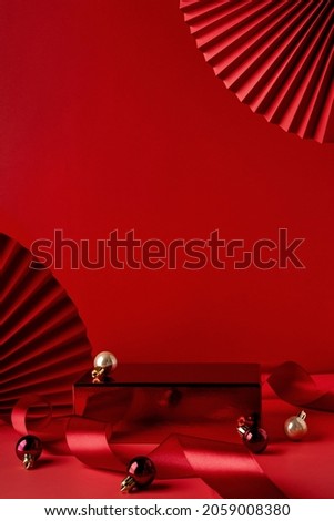 Red podium for christmas product display on red background. Product display stand. Christmas baubles decoration