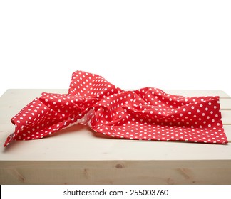 Red polka dot tablecloth or towel over the surface of a wooden table, composition isolated against the white background - Powered by Shutterstock