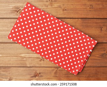 Red polka dot tablecloth or towel over the surface of a brown wooden table - Powered by Shutterstock