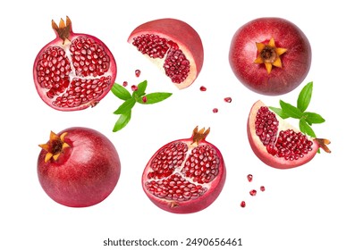 Red pomegranate with seeds and green leaves flying in the air isolated on white background.