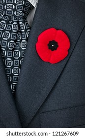 Red Poppy Lapel Pin On Suit Jacket For Remembrance Day
