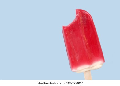 A Red Popsicle With A Bite Taken From It.