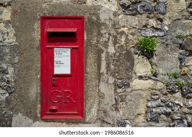 Red post box embedded in old city walls